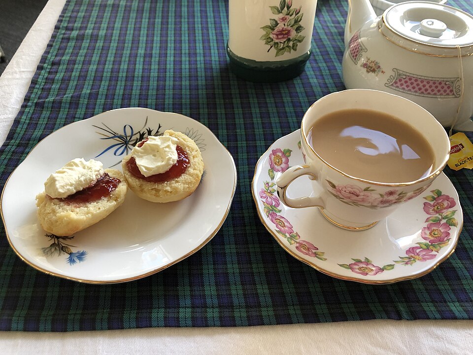 Scones with jam and cream, a cup of tea and a china teapot