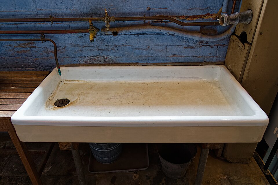A large white ceramic sink in the historic kitchen at Charlecote Park, Warwickshire