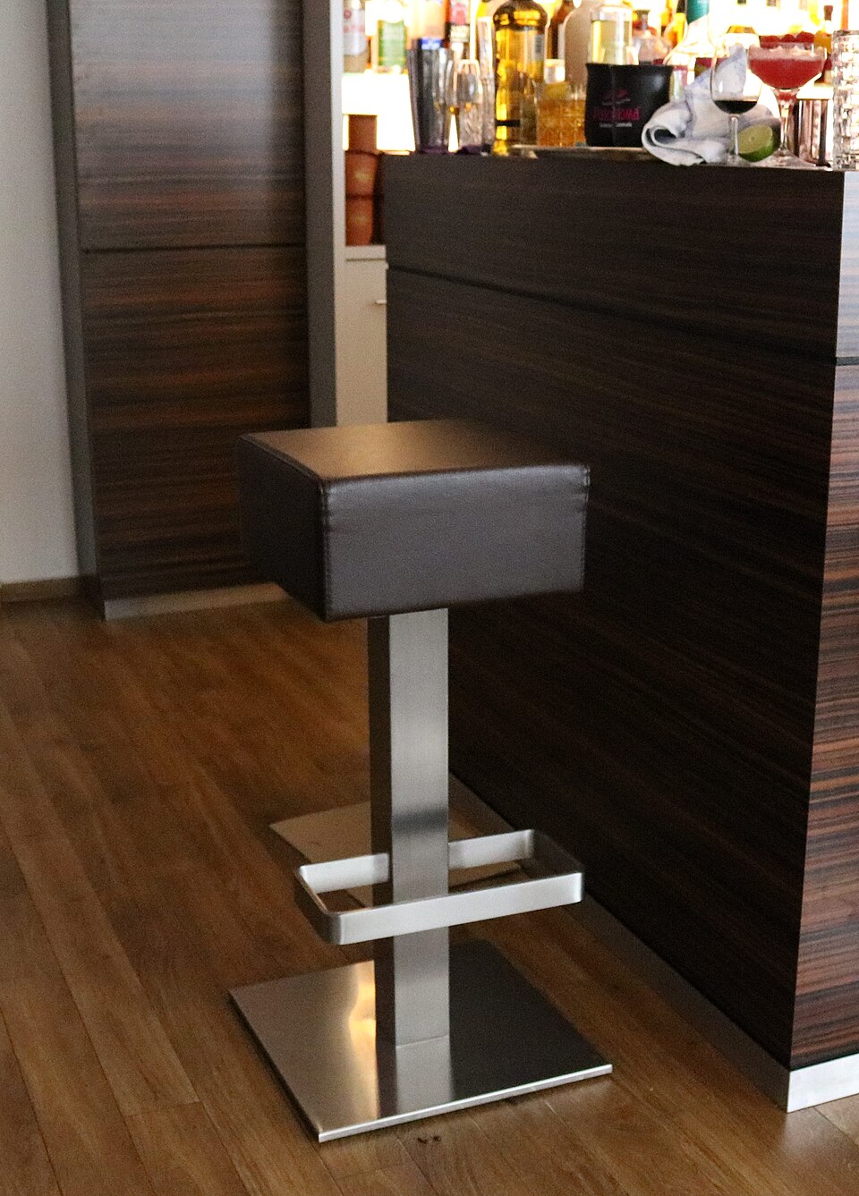 A height-adjustable bar stool with a square seat