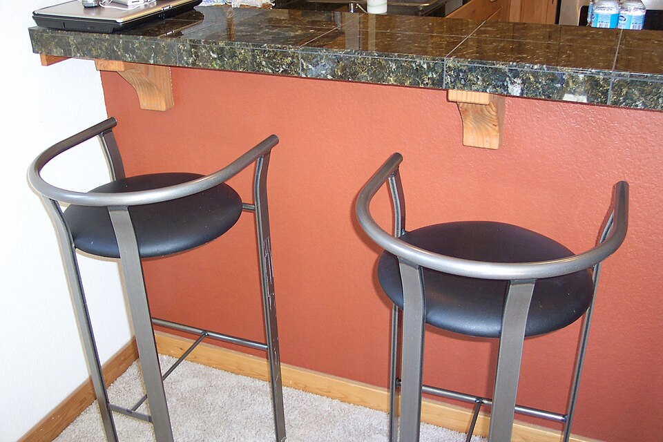 Two metal bar stools at a granite breakfast bar
