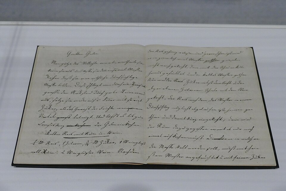 A handwritten family cookbook open on a stand