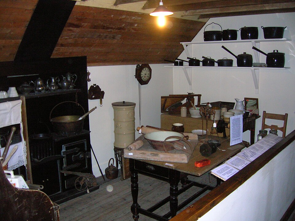 A restored Victorian kitchen with a range, dresser and scrubbed table