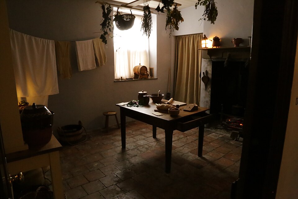 A traditional English cottage kitchen with a scrubbed table and stone floor