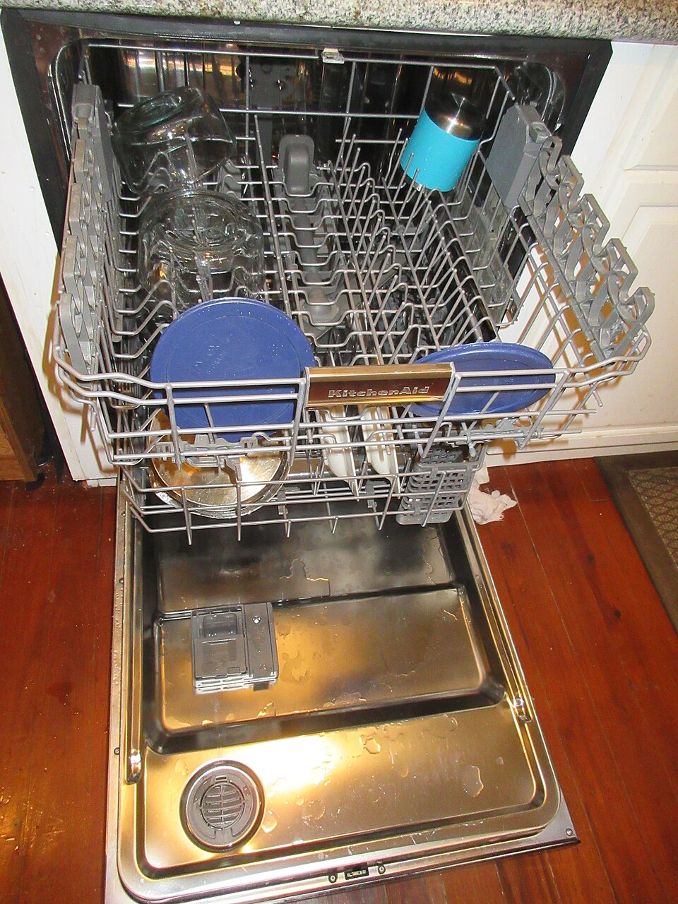 An open dishwasher loaded with plates and bowls