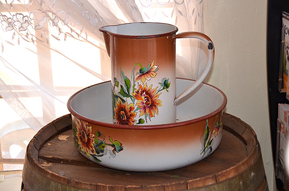 An enamel jug and wash basin decorated with flowers