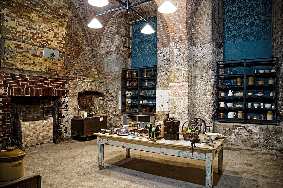 A historic country-house kitchen with deep blue painted shelving