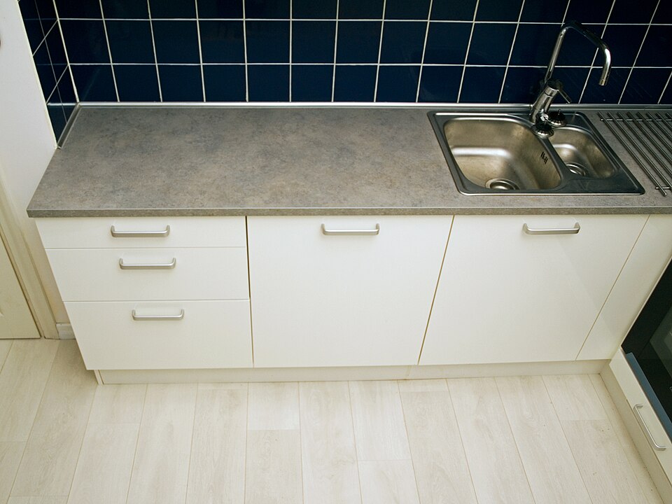 A run of white kitchen units with the appliances hidden behind matching doors