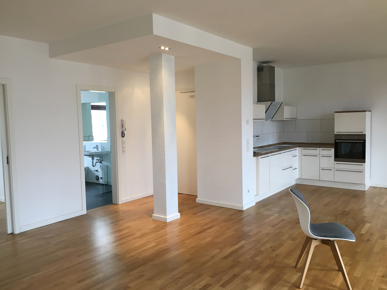 A single-wall fitted kitchen along one side of an open-plan room