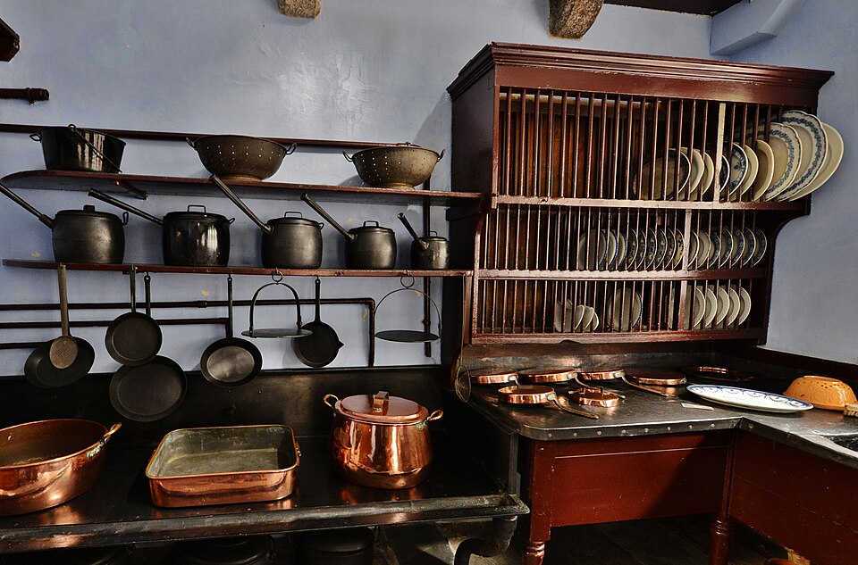 A plate rack and copper pans in a historic country-house kitchen