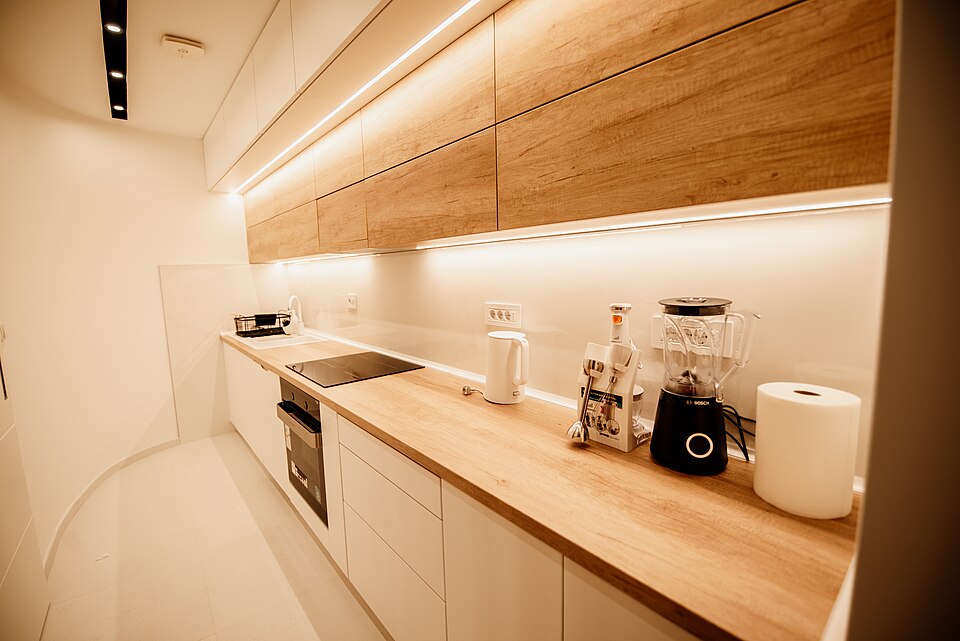 A kitchen worktop lit by LED strips under the wall cabinets