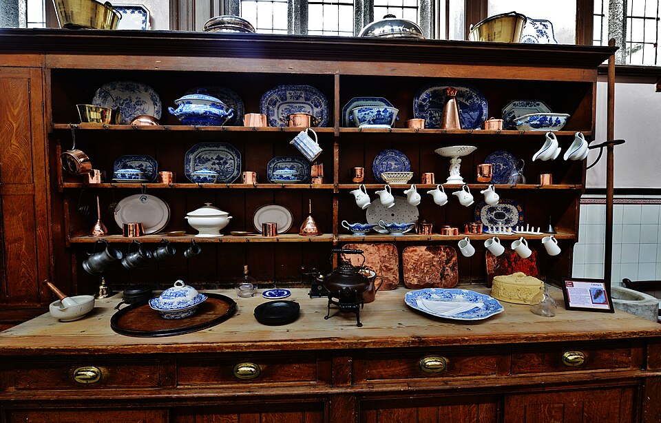 A long freestanding dresser in the kitchen at Lanhydrock House, laden with china
