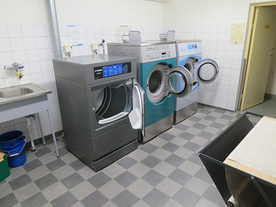 A laundry room with washing machines and a sink
