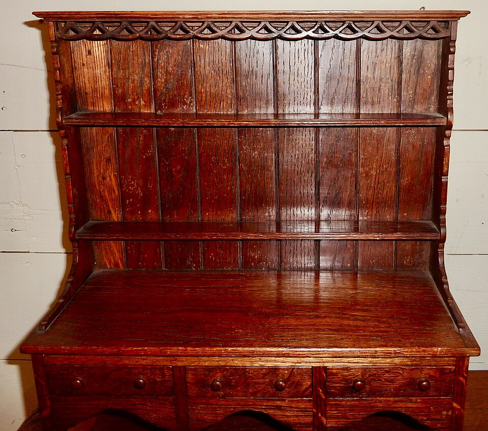 An oak Welsh dresser, showing the cupboard base and open rack