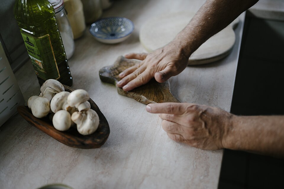 Hands kneading dough on a kitchen worktop