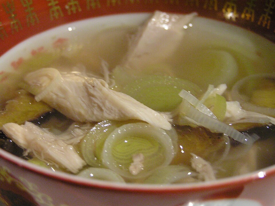 A bowl of cock-a-leekie soup with shredded chicken and leeks