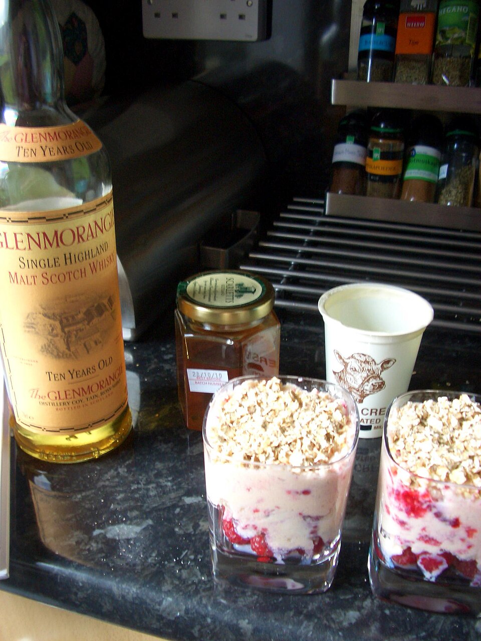 Glasses of cranachan beside a bottle of Scotch whisky