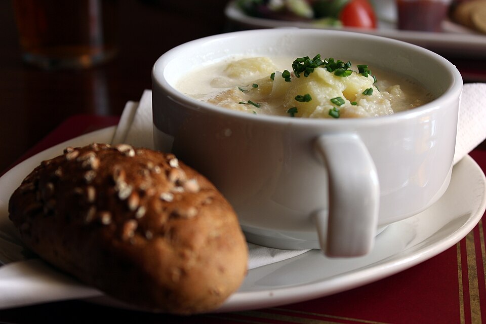 A bowl of Cullen skink with a bread roll