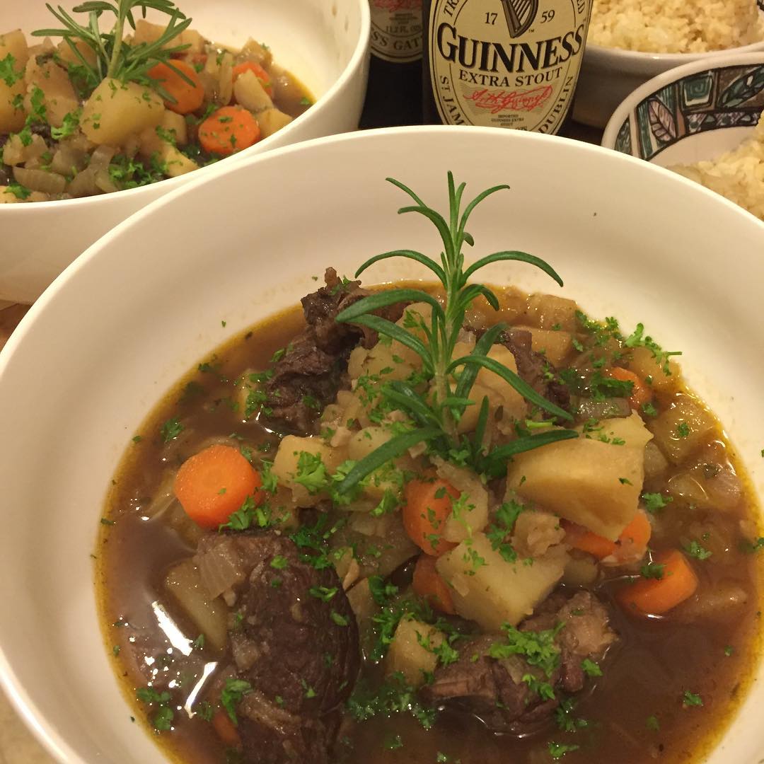 A bowl of Irish lamb stew with potatoes, carrots and a sprig of rosemary