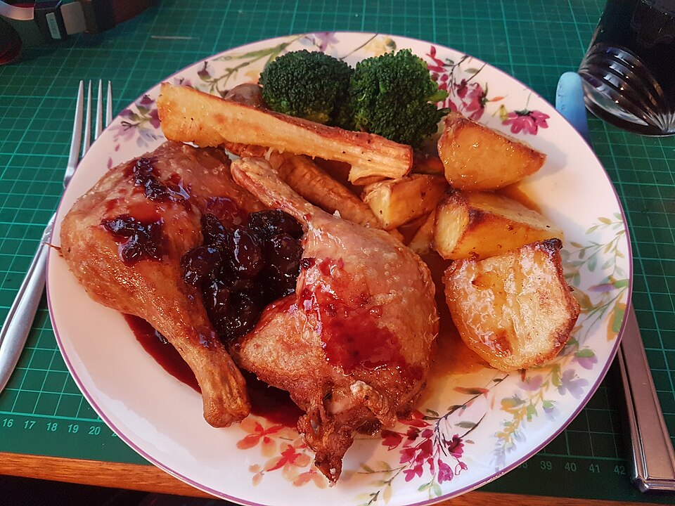 Roast potatoes served with roast duck, parsnips and broccoli