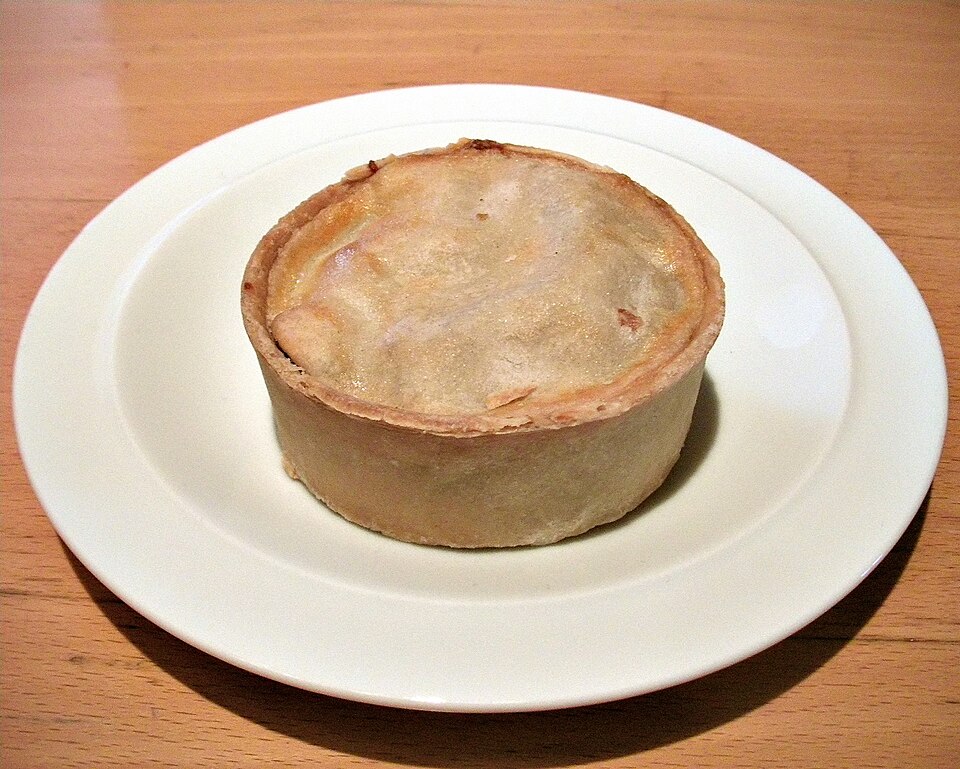 A round Scotch pie on a white plate