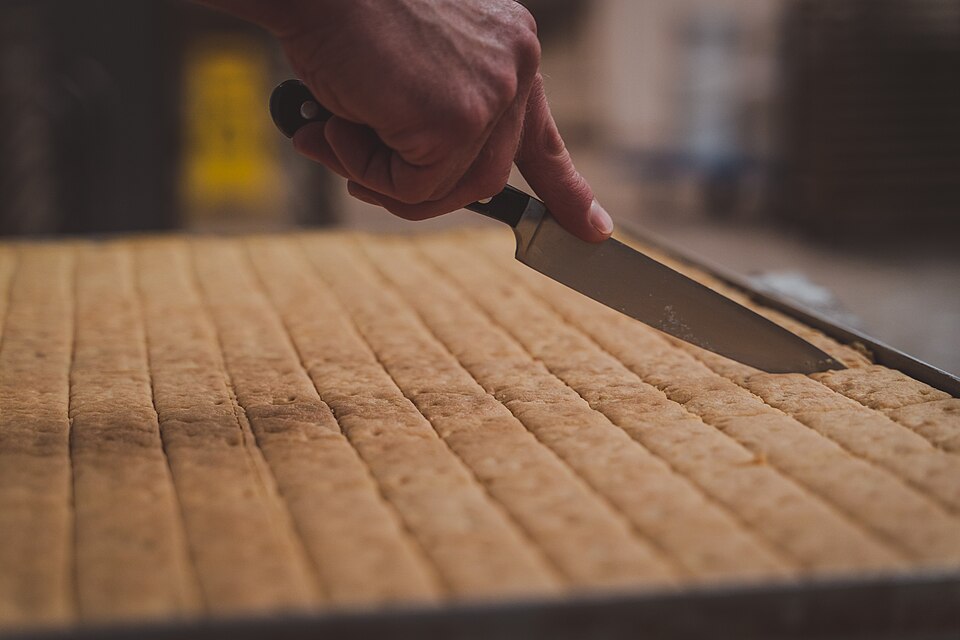 A tray of shortbread being cut into fingers
