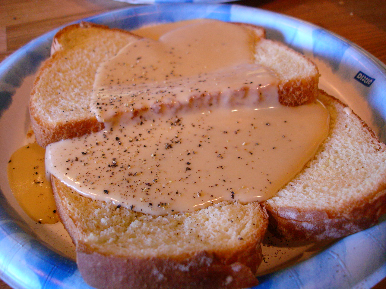 Slices of Welsh rarebit, grilled and seasoned with black pepper