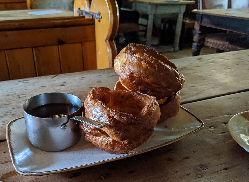 Yorkshire puddings served with a small pan of gravy