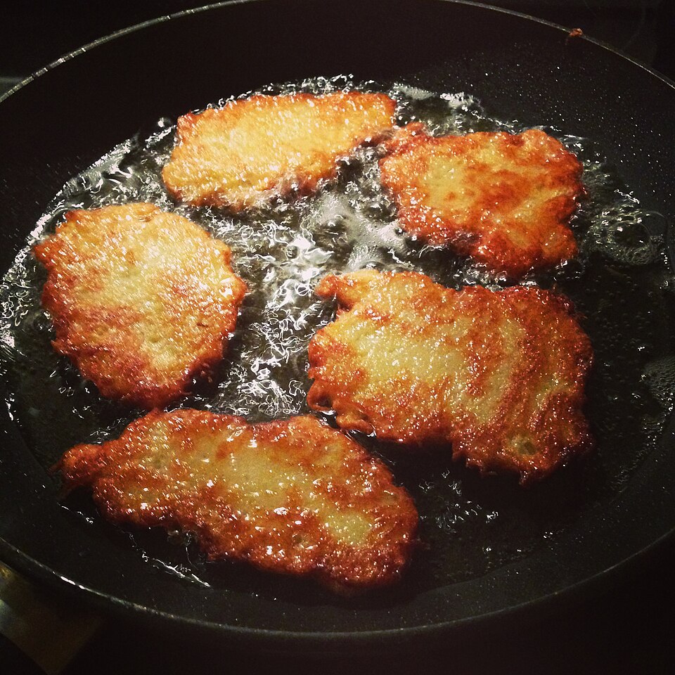 Potato pancakes frying in a pan