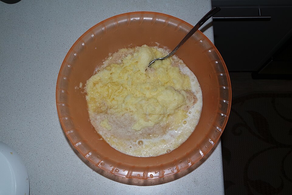 A bowl of grated potato pancake mixture