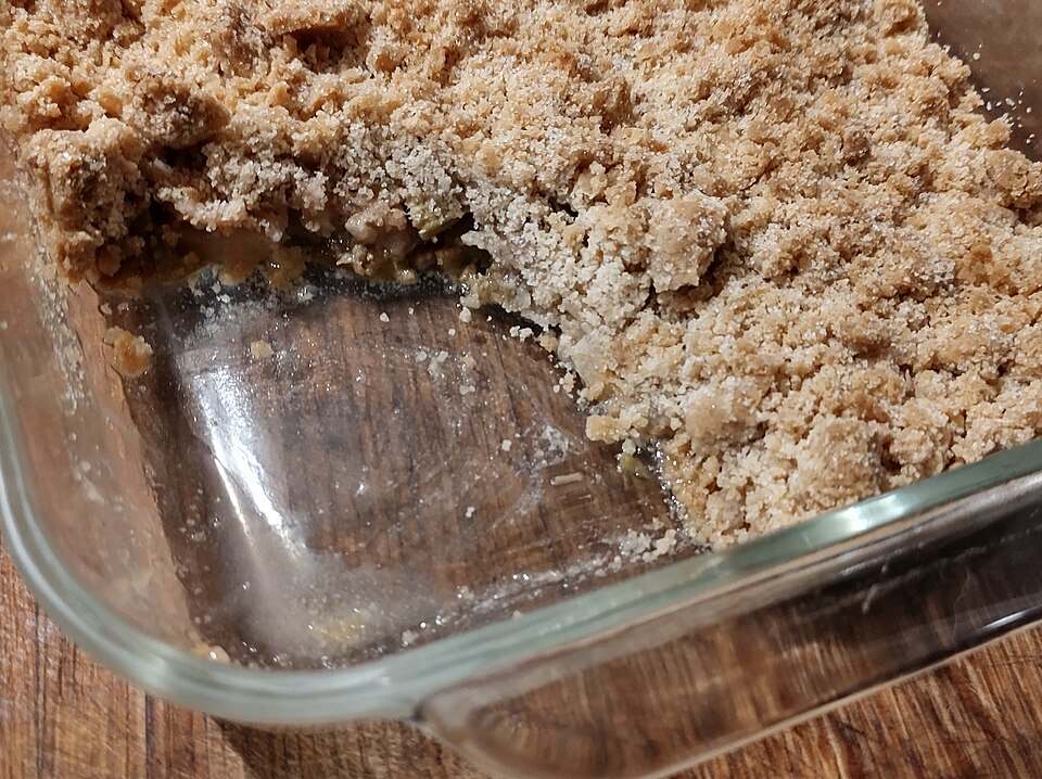 A baked apple crumble with a portion taken out