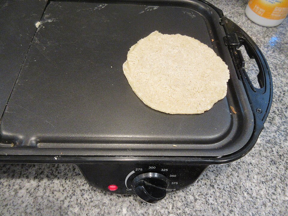 A flatbread cooking on a flat griddle