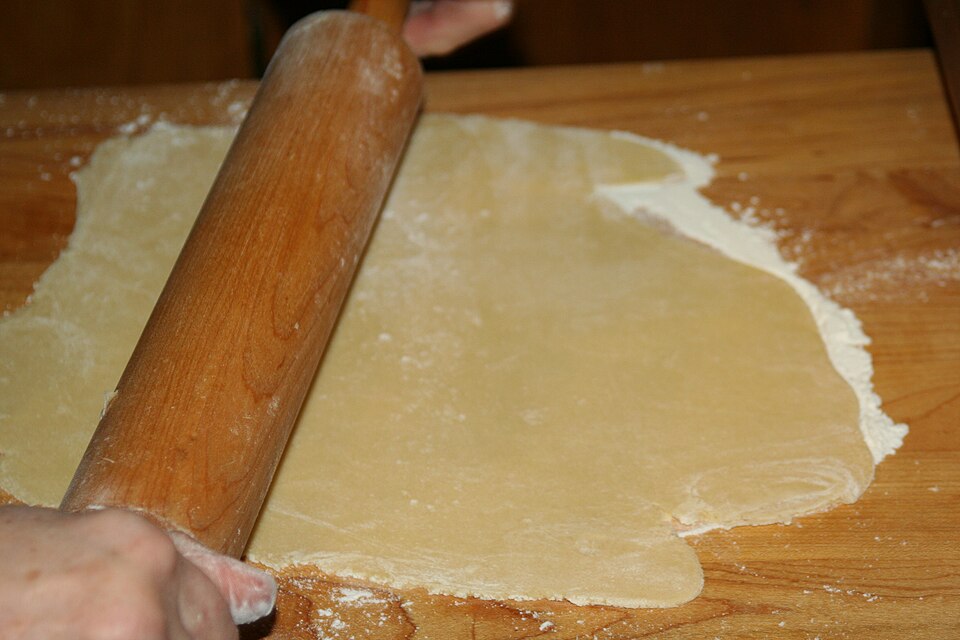 Rolling out dough with a wooden rolling pin