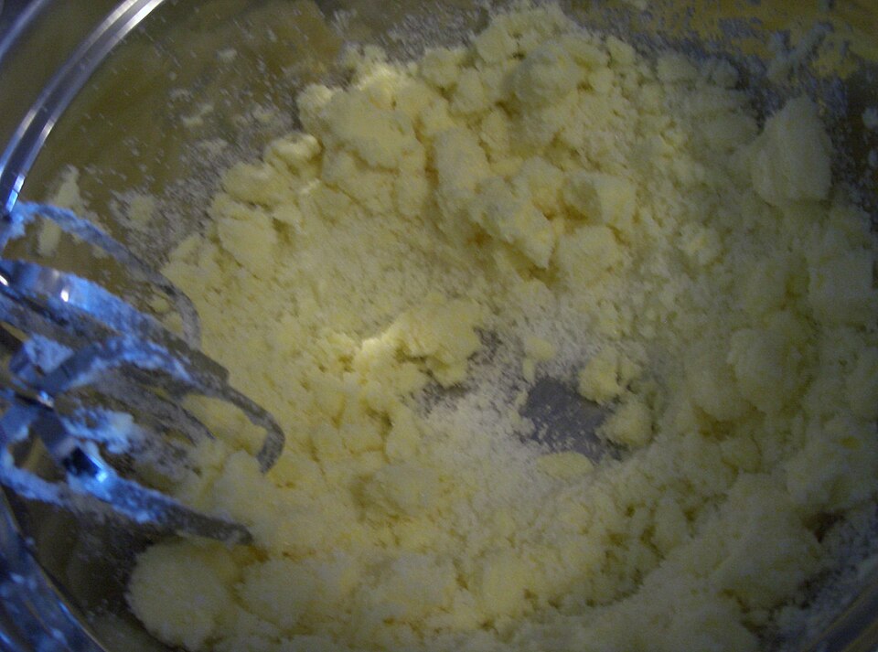 Butter and sugar being creamed with an electric mixer