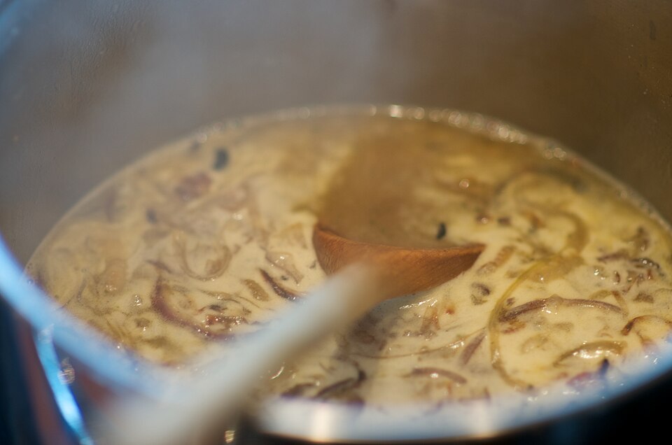 Onion gravy being stirred in a pan