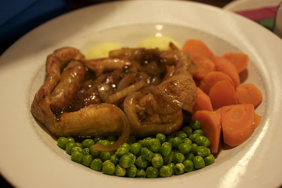 Toad in the hole with onion gravy, peas and carrots