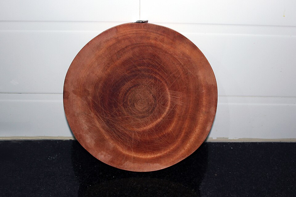 A round end-grain wooden chopping board