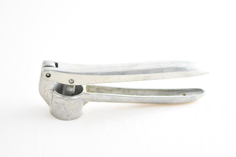 A metal garlic press
