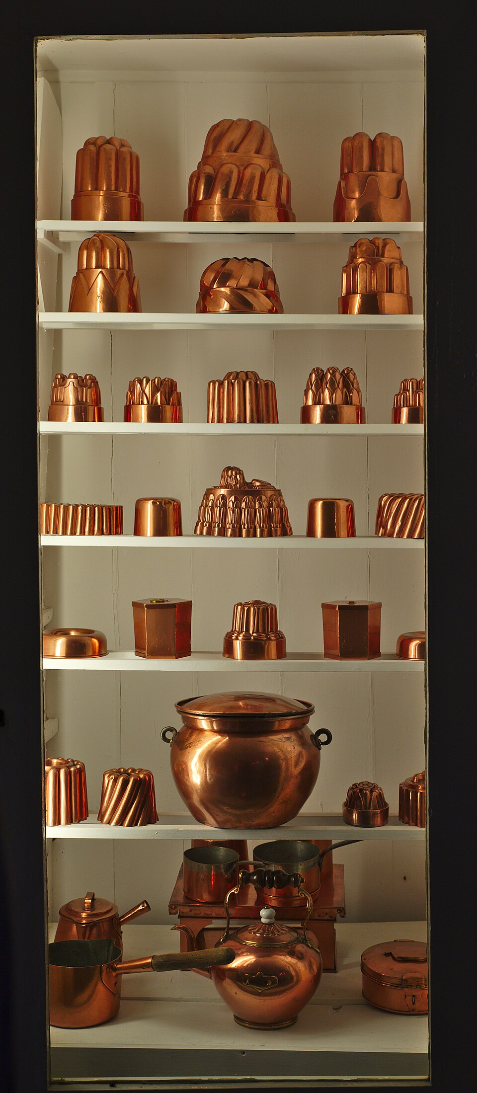 Shelves of antique copper jelly moulds