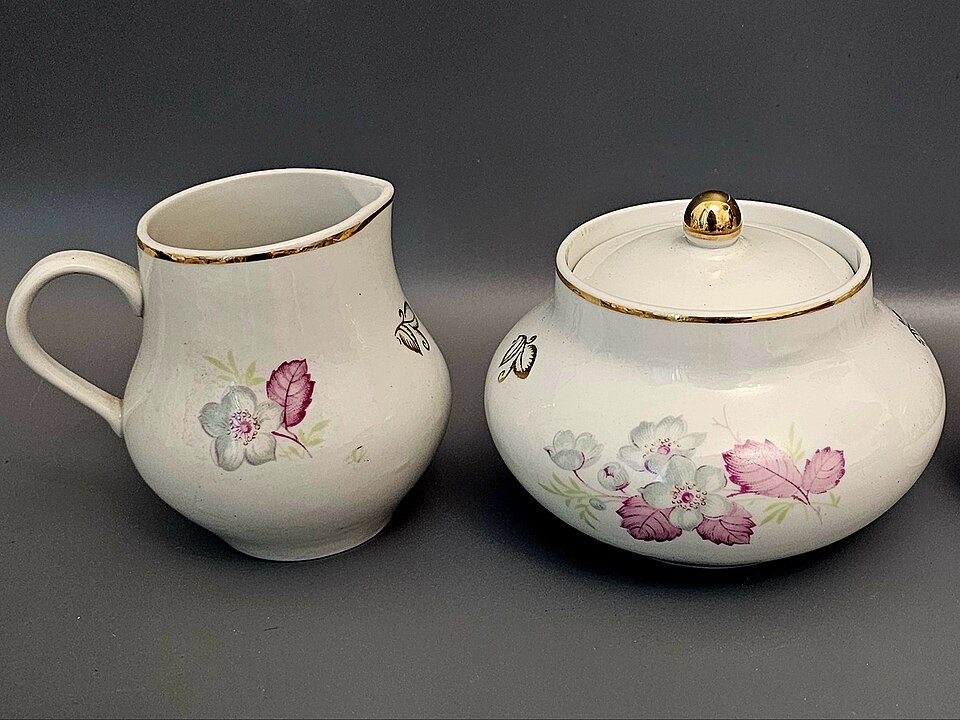 A porcelain milk jug and lidded sugar bowl with a floral pattern