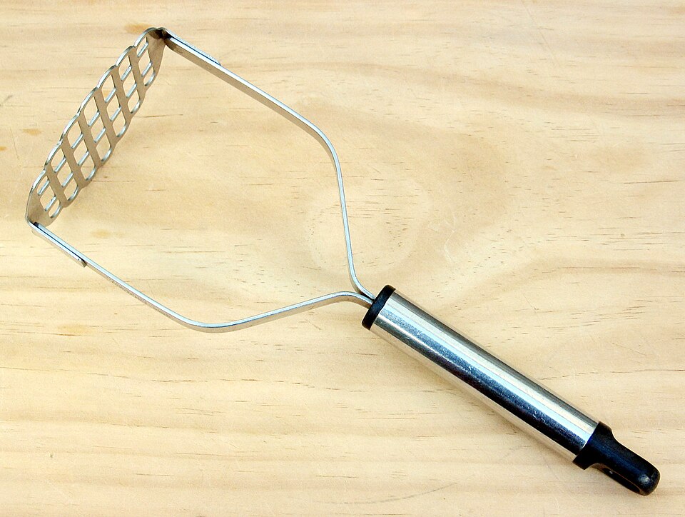 A stainless steel grid potato masher