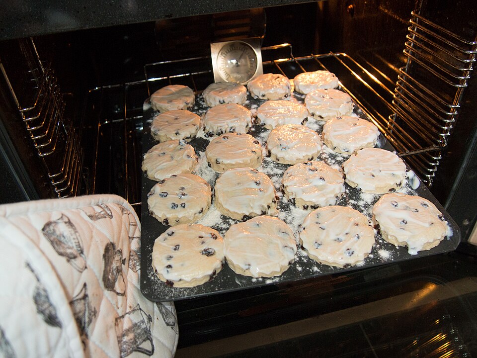 Round-cut scones on a baking tray going into the oven