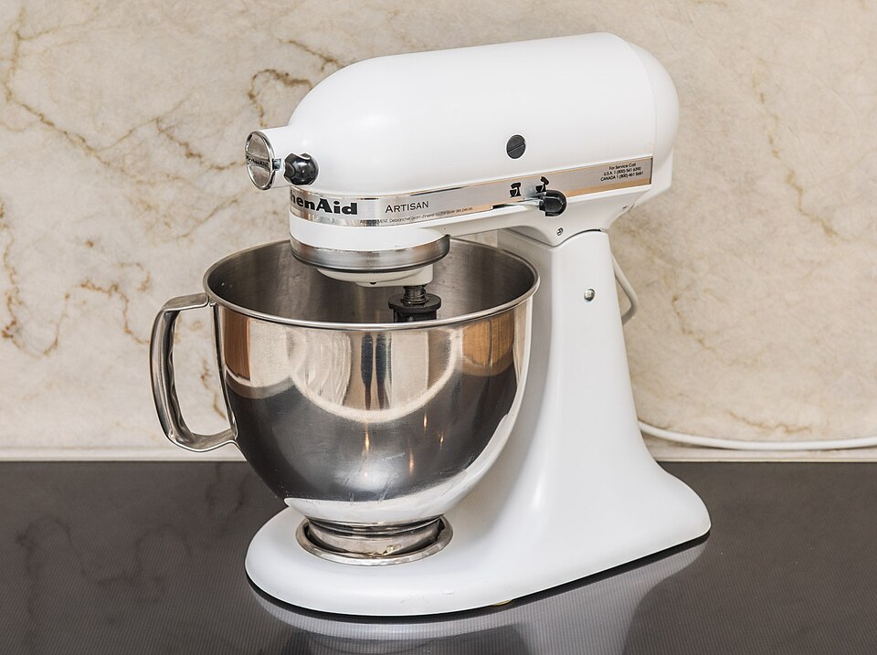 A white stand mixer with a stainless steel bowl