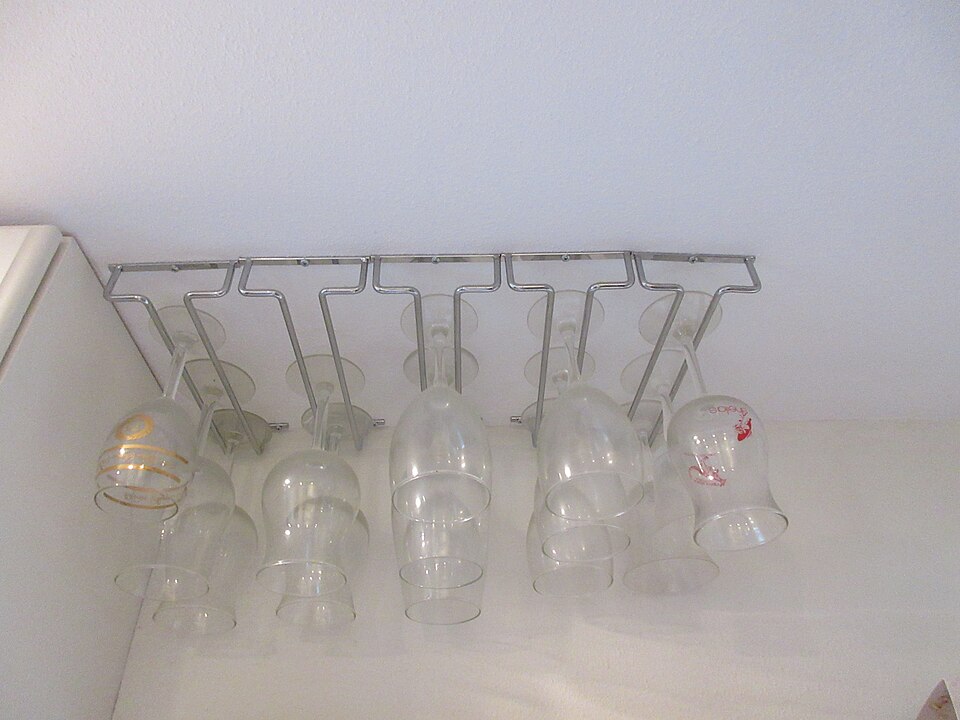 Wine glasses hanging upside down from an under-cabinet rack