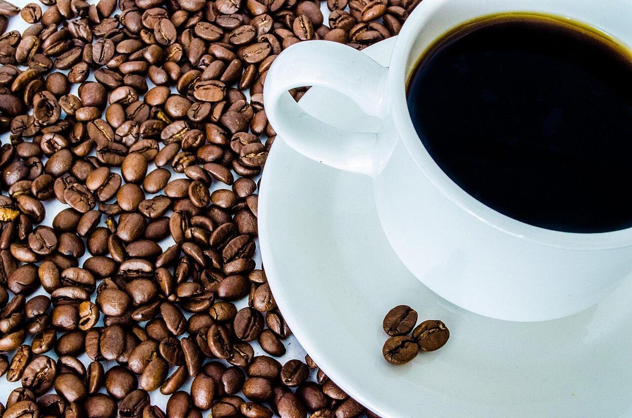 Cup of black coffee on a bed of coffee beans