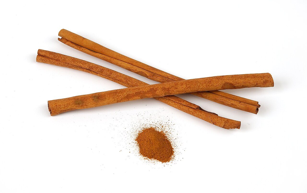 Cinnamon sticks and ground cinnamon on white