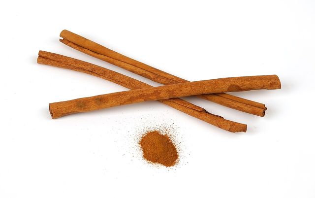 Cinnamon sticks and ground cinnamon on white