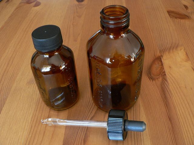 Brown glass dropper bottles on a wooden table