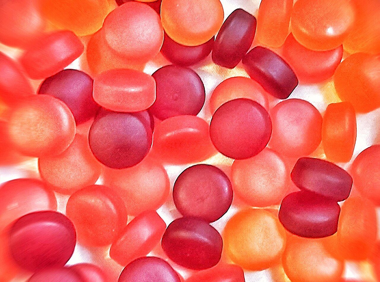 Pile of red and orange supplement gummies