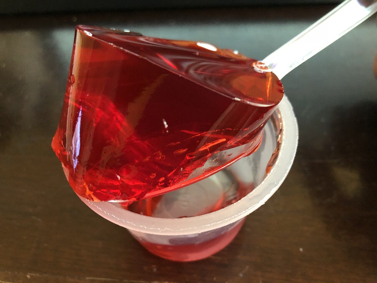 Red fruit gelatin tipped out of a cup