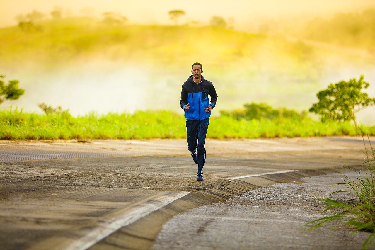 Man running along a road at sunrise